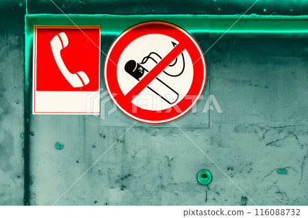Prohibition sign no smoking, telephone sign on a dirty scratched green wall Prohibition sign no smoking, telephone sign on a dirty scratched green wall 116088732