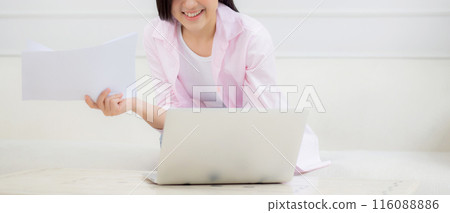 Young asian business woman working on laptop computer and looking graph and chart of report. Young asian business woman working on laptop computer and looking graph and chart of report. 116088886