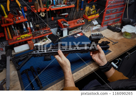 Man putting gun with ammunition in safety case top view closeup Man putting gun with ammunition in safety case top view closeup 116090265