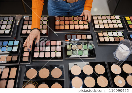 Lady choosing eye shadow palette in cosmetics shop 116090455