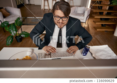 Exited businessman typing keyboard working online at home office 116090629