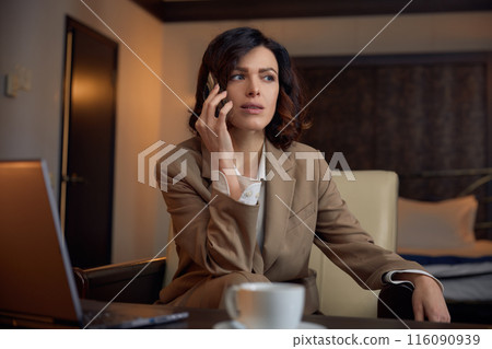 Fashioned stylish businesswoman wearing formalwear working in hotel room 116090939