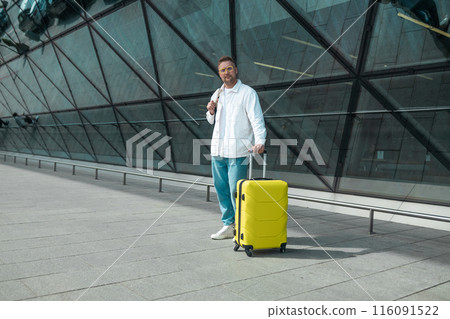 Young Caucasian male passenger in stylish casual clothes using smartphone and laptop keyboard, sit has training online meeting on laptop computer in airline lounge wait transit international airport Young Caucasian male passenger in stylish casual clothes using smartphone and laptop keyboard, sit has training online meeting on laptop computer in airline lounge wait transit international airport 116091522