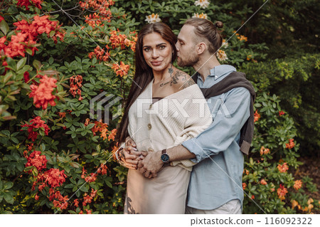 Young fun surprised couple family man woman in rest relax together boyfriend meet girlfriend. Close-up portrait of a girl with a freckled face standing and hugging his neck in the sunlight. Young fun surprised couple family man woman in rest relax together boyfriend meet girlfriend. Close-up portrait of a girl with a freckled face standing and hugging his neck in the sunlight. 116092322