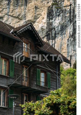Charming wooden house with balconies against Swiss mountains, offers a picturesque retreat in alpine scenery 116092984