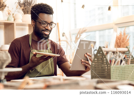 Dark-skinned sculptor demonstrating a new product on a webinar 116093014