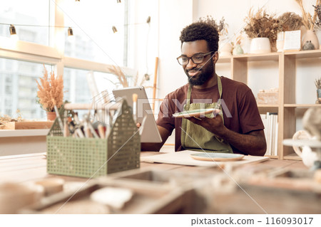 Dark-skinned sculptor demonstrating a new product on a webinar 116093017