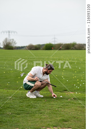 Male athlete playing golf on grass training alone on green course 116093100