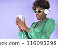 Woman Wearing Headphones and Holding Game Controller 116093298