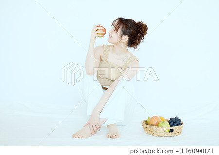 Portrait of a woman holding an apple 116094071