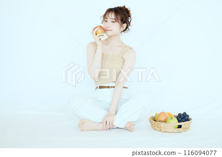 Portrait of a woman holding an apple Portrait of a woman holding an apple 116094077