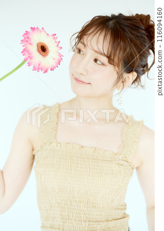 Portrait of a woman holding a gerbera Portrait of a woman holding a gerbera 116094160
