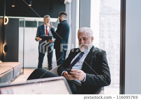 Senior businessman using smartphone in office 116095769
