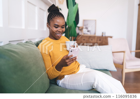 Smiling black woman with cup of coffee Smiling black woman with cup of coffee 116095836