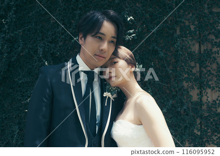 Bride and groom in tuxedo and wedding dress 116095952