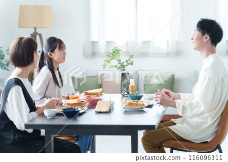 Parents and children eating breakfast in the living room 116096311