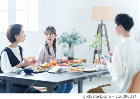 Parents and children eating breakfast in the living room 116096314