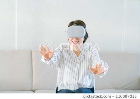 一位女士戴著 VR 護目鏡享受虛擬現實 116097013