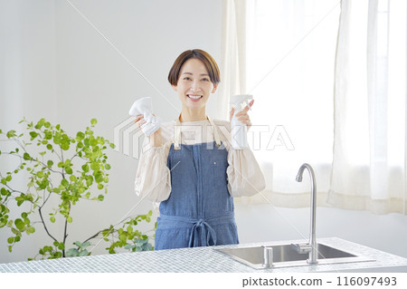 一位家庭主婦打掃廚房的肖像，看著相機 116097493