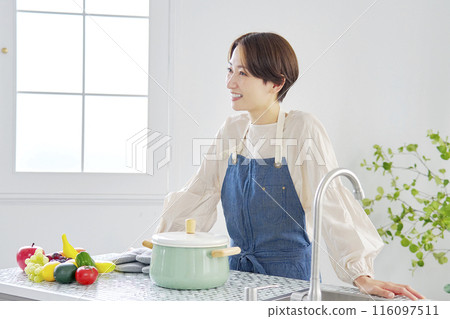 Portrait of a woman standing in the kitchen Portrait of a woman standing in the kitchen 116097511