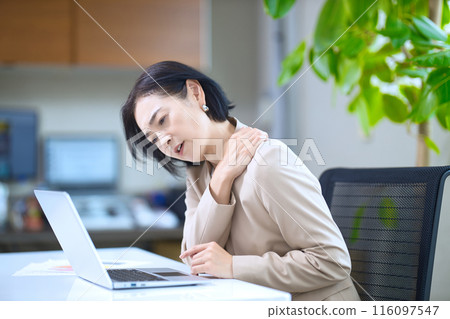 Middle-aged woman showing signs of fatigue in the office Middle-aged woman showing signs of fatigue in the office 116097547