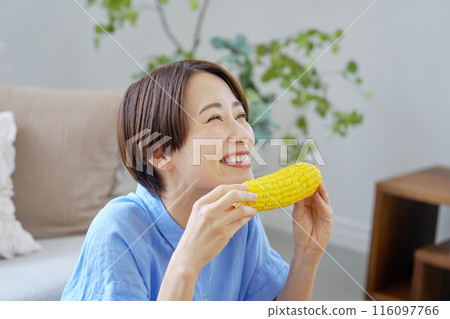 Woman eating corn at home 116097766