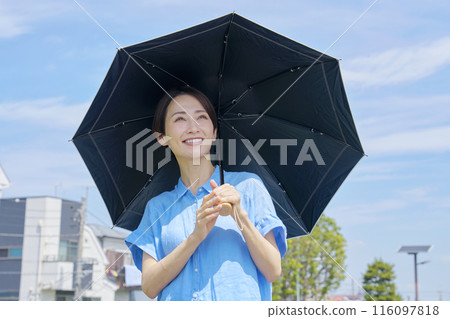 Smiling woman with a parasol outdoors 116097818