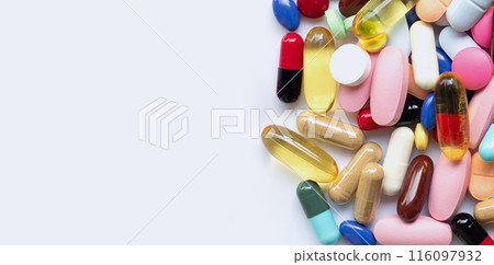 Colorful tablets with capsules and pills on white. 116097932