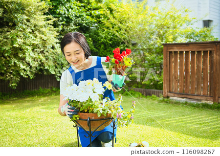 一位微笑的中年婦女正在種樹 一位微笑的中年婦女正在種樹 116098267