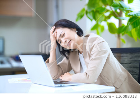 辦公室裡一臉酸澀地抱著頭的中年婦女 116098318