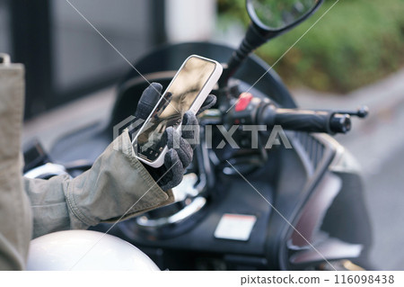 一名騎摩托車的女士正在使用智慧型手機 一名騎摩托車的女士正在使用智慧型手機 116098438