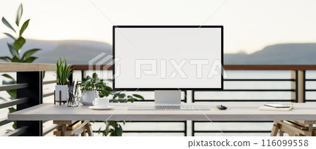 A computer desk on a balcony with a mountain view, a computer with a white-screen mockup. 116099558