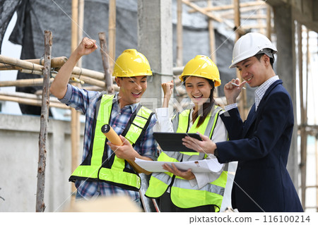 Construction workers in safety helmets celebrating a successful project on construction site 116100214