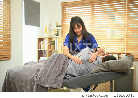 Rehabilitation specialist manipulating shoulder blade male patient in manual therapy clinic 116100313