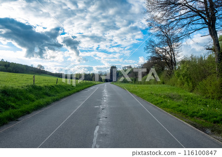 Enjoy a tranquil drive along a beautiful countryside road beneath a stunning sky Enjoy a tranquil drive along a beautiful countryside road beneath a stunning sky 116100847