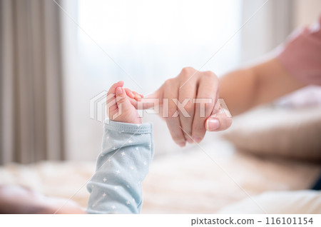 A close-up image with a copy space of a newborn baby holding his mom's finger. family bonding 116101154