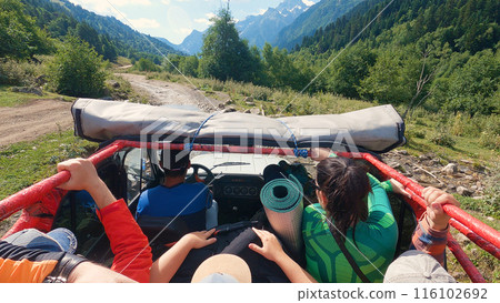 Outdoor Excursion. A group of people in an off-road vehicle, wearing outdoor clothing, set out to find adventure in a lush mountainous area. Outdoor Excursion. A group of people in an off-road vehicle, wearing outdoor clothing, set out to find adventure in a lush mountainous area. 116102692