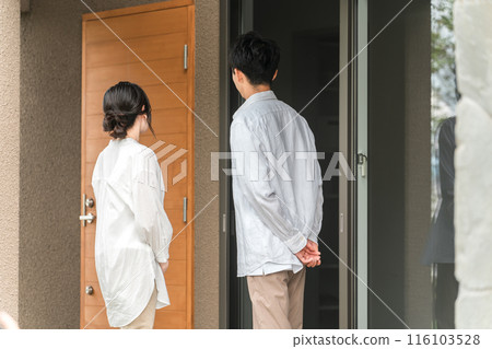 一對已婚夫婦、夫妻或家庭站在新建住宅、獨立住宅或獨立建築前的後視圖 116103528