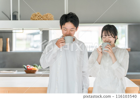 A couple drinking coffee, tea or hot drinks in the dining room at home 116103540