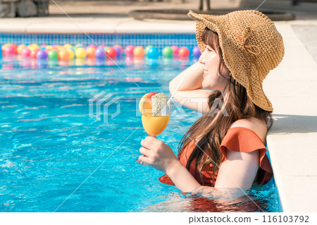 年輕的亞洲女性在度假村度假時在泳池裡喝熱帶飲料 116103792