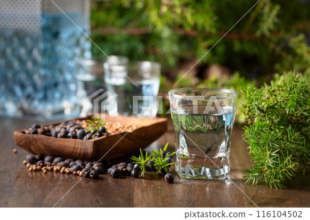 Gin with ingredients on an old wooden table. Gin with ingredients on an old wooden table. 116104502