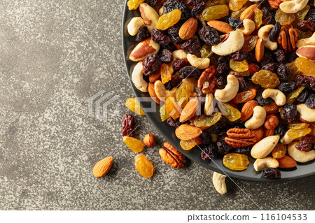 Mix of dried nuts and raisins on a rustic background. 116104533
