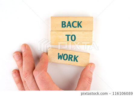 Conceptual business symbol. Copy space. Back to work words written on wooden blocks laid out by hand on a white background Conceptual business symbol. Copy space. Back to work words written on wooden blocks laid out by hand on a white background 116106089