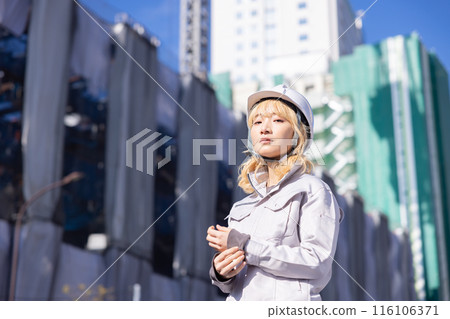 穿著工作服在建築工地工作的女商人 116106371