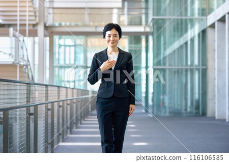 穿著西裝的中層女商人站在走廊上 穿著西裝的中層女商人站在走廊上 116106585
