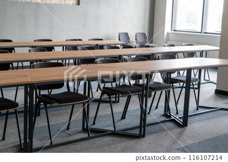 Empty room with tables and chairs for studying. University or school auditorium. Furniture in the interior. Modern style. Back to school. 116107214