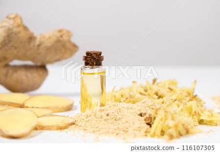 Natural ginger oil in glass bottle among ginger roots 116107305