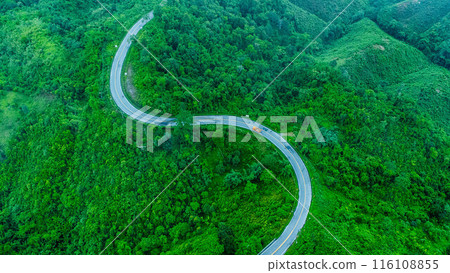Aerial view of a road in the middle of a forest, construction of a curved road up the mountains in northern Thailand. 116108855