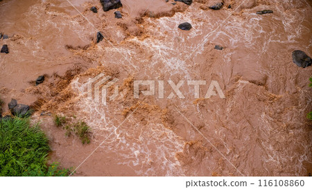 Close-up aerial view of the mighty Mekong River shows its muddy waterways flowing hard and fast during the rainy season. Close-up aerial view of the mighty Mekong River shows its muddy waterways flowing hard and fast during the rainy season. 116108860