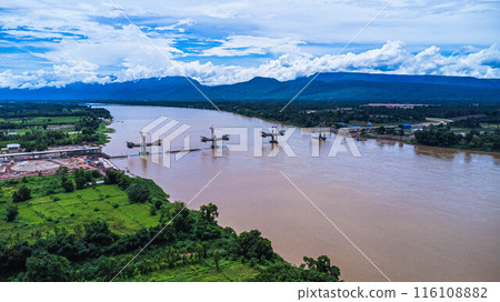 Aerial view of the construction site of the bridge over the Mekong River. Construction of a new Thai-Lao Friendship Bridge in Bueng Kan Province, Thailand. Aerial view of the construction site of the bridge over the Mekong River. Construction of a new Thai-Lao Friendship Bridge in Bueng Kan Province, Thailand. 116108882